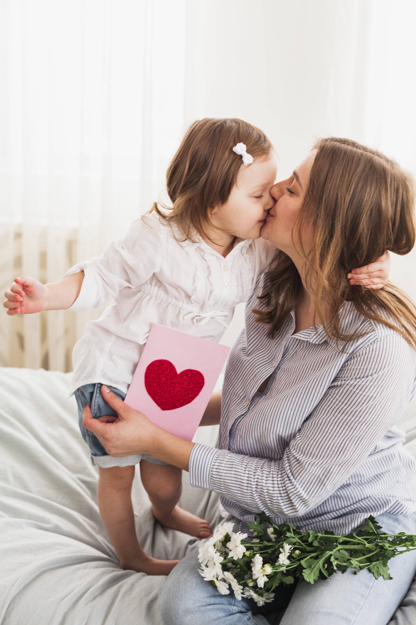 Madre e hija sonriendo juntas, reflejando amor y alegría en el Día de las Madres.