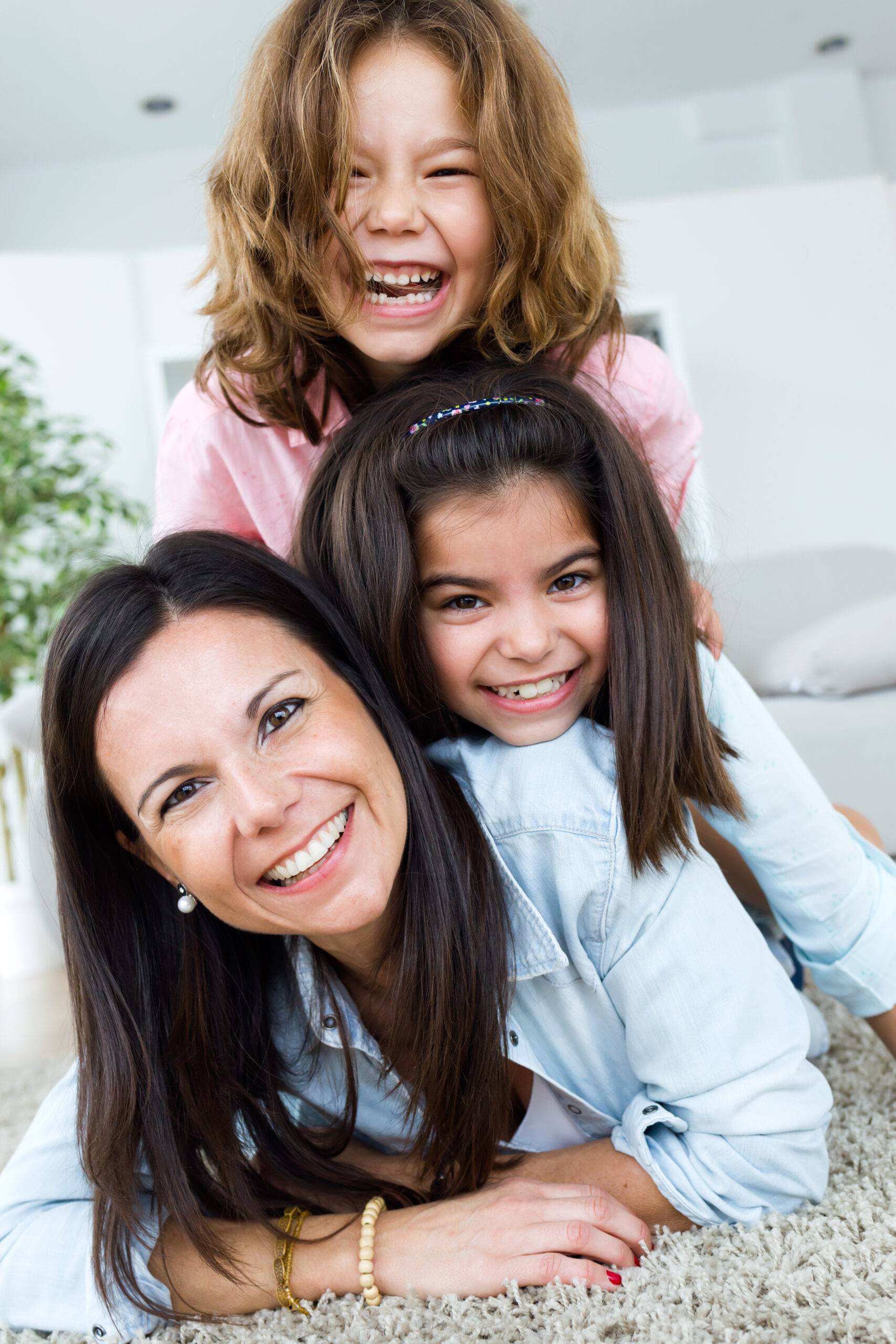 Mamá sonriendo con sus hijas, compartiendo una sonrisa radiante y feliz en el Día de las Madres